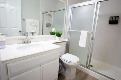 a white bathroom with a toilet and a shower at CA2 House SoCal Oasis Newly Renovated Game Room in La Palma