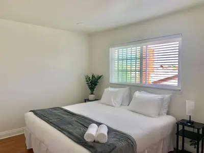a bedroom with a white bed with white shoes on it at CA3 House Spacious SoCal Home for Groups in La Palma