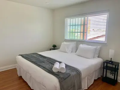 a bedroom with a large white bed with white shoes on it at CA3 House Spacious SoCal Home for Groups in La Palma