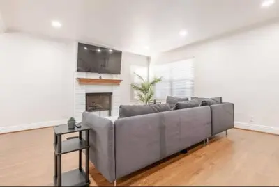 a living room with a gray couch and a fireplace at CA3 House Spacious SoCal Home for Groups in La Palma