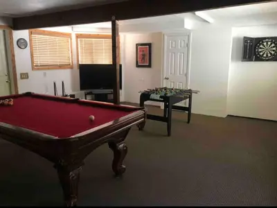 a living room with a pool table and a tv at Lakefront Oasis in Fawnskin