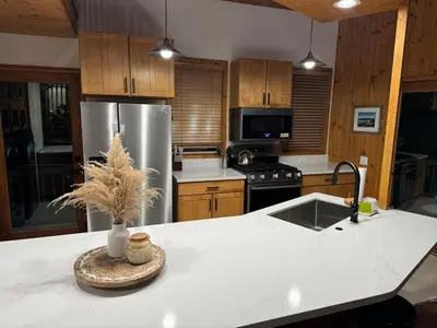 a kitchen with a stainless steel refrigerator and a sink at Lakefront Oasis in Fawnskin