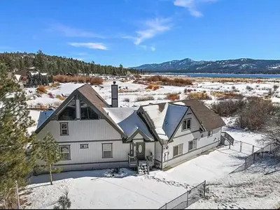 a large white house with snow on the ground at Lakefront Oasis in Fawnskin