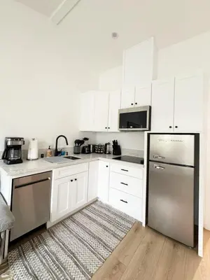a kitchen with white cabinets and a stainless steel refrigerator at Relaxing 2BR Escape in Trendy West LA - CM-CAL in Calabasas