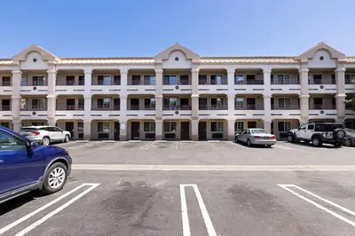 a large white building with cars parked in a parking lot at Paradise Lodge - Canoga Park, Los Angeles in Winnetka