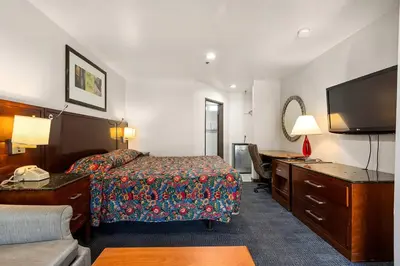 a hotel room with a bed and a flat screen tv at Paradise Lodge - Canoga Park, Los Angeles in Winnetka