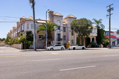 two cars parked in front of a building on a street at Paradise Lodge - Canoga Park, Los Angeles in Winnetka