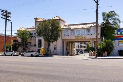 a building with cars parked in front of a street at Paradise Lodge - Canoga Park, Los Angeles in Winnetka