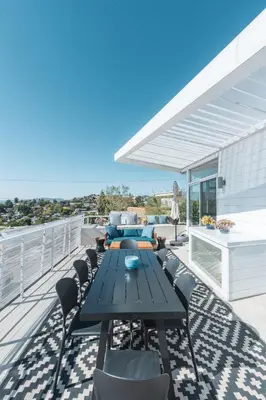 a patio with a table and chairs on a deck at Industrial&Stylish 3 bedroom 3 bathrooms Home With Views and Hot tub in Los Angeles