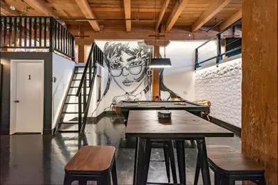 a room with a table and a mural of a boy at Arts District DTLA-Artist Loft With Free Parking and Pooltable in Los Angeles