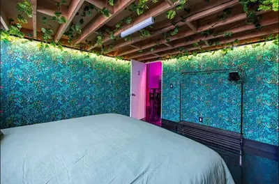 a bedroom with a bed and a green wall at Arts District DTLA-Artist Loft With Free Parking and Pooltable in Los Angeles