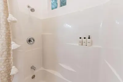 a white bathroom with a tub and a shower at Welcoming Claremont Studio With Private Yard and Pool Spa in Claremont