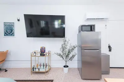 a kitchen with a refrigerator and a table with a plant at Renovated Stylish Guesthouse By Claremont With Private Patio in Montclair