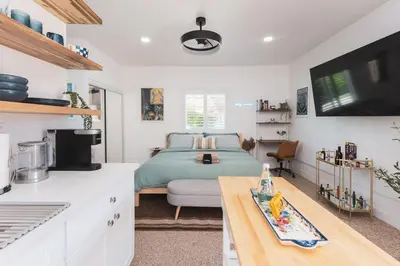 a bedroom with a bed and a kitchen with a table at Renovated Stylish Guesthouse By Claremont With Private Patio in Montclair
