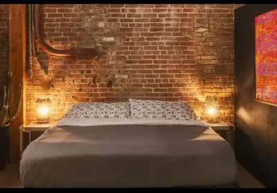 a bedroom with a bed and a brick wall at 1400 square foot Arts District Warehouse Loft 1 bedroom 1 bathroom in Los Angeles