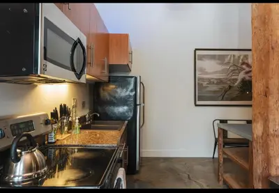a kitchen with a sink and a refrigerator at 1400 square foot Arts District Warehouse Loft 1 bedroom 1 bathroom in Los Angeles