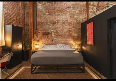 a bedroom with a bed in a brick wall at 1400 square foot Arts District Warehouse Loft 1 bedroom 1 bathroom in Los Angeles