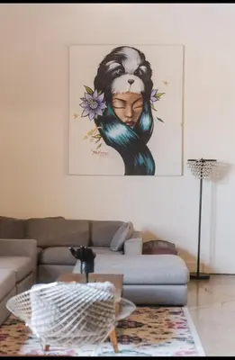 a living room with a couch and a painting of a woman at 1400 square foot Arts District Warehouse Loft 1 bedroom 1 bathroom in Los Angeles