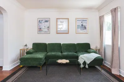 a living room with a green couch and a table at Charming Vintage 2 bedroom 1 Bathroom Close to Larchmont Village in Los Angeles