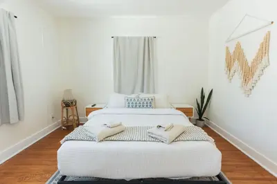 a bedroom with a white bed with two towels on it at Quaint Updated 2 bedroom 1 bathroom Cottage Near Larchmont Village in Los Angeles