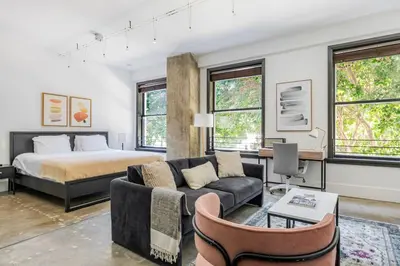 a living room with a bed and a couch at Blueground Historic Core view nr Grand Park LAX-1424 in Los Angeles