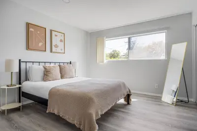 a white bedroom with a bed and a window at Blueground Melrose pool nr Griffith Park LAX-1399 in Los Angeles