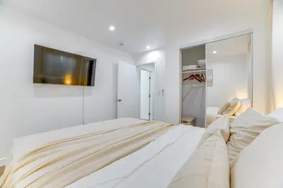 a white bedroom with a large bed and a tv at Work and Play! Apt Less Than 1 Mi to Chino Valley Hospital in Chino