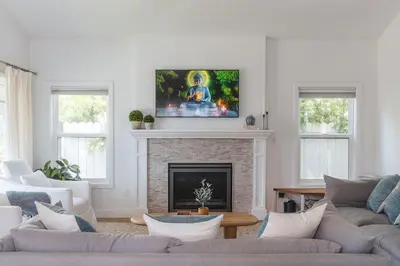 a living room with a fireplace with a tv above it at Naples Island Stunning Ocean Cottage By the Beach in Long Beach