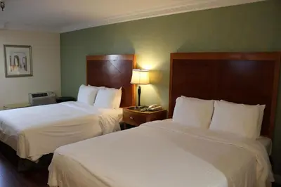 a hotel room with two beds with white sheets at Garvey Inn Hotel - \u5c0f\u53f0\u5317\u9152\u5e97, Monterey Park in Monterey Park