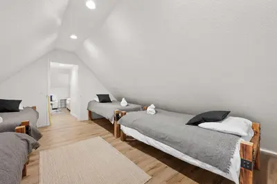a bedroom with two beds and a white wall at Navigate Stays 5BR Group Lodge Near Mountain & Fun in Big Bear Lake