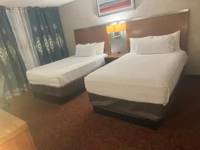 a hotel room with two beds and a window at Hiltop Hotel in Bakersfield