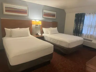 a hotel room with two beds and a window at Hiltop Hotel in Bakersfield
