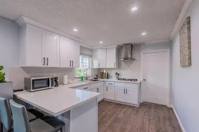 a white kitchen with white cabinets and a microwave at Cozy Comfort LA House with Stunning Scenic Views in Monterey Park