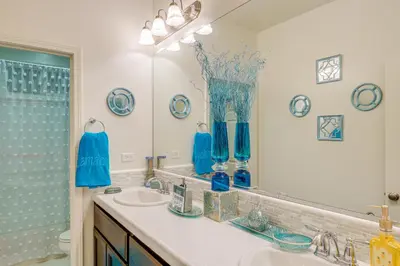a bathroom with a sink and a mirror with blue vases at 4 Mi to CSUB Campus Spacious Home with Yard in Bakersfield