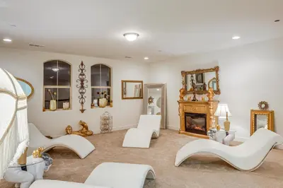 a living room with white furniture and a fireplace at 4 Mi to CSUB Campus Spacious Home with Yard in Bakersfield