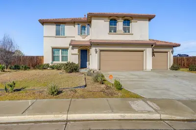 a house with a driveway and a garage at 4 Mi to CSUB Campus Spacious Home with Yard in Bakersfield