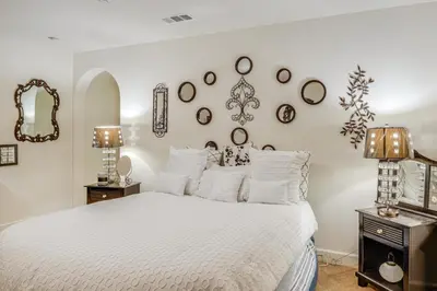 a bedroom with a white bed with mirrors on the wall at 4 Mi to CSUB Campus Spacious Home with Yard in Bakersfield