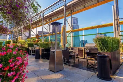 a rooftop patio with tables and chairs and flowers at Modern 2BR Loft with Luxury Amenities - 109 - GL in Glendale