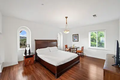 a bedroom with a bed and a table and chairs at Mountain View Luxury Estate with Pool in West Hills in Chatsworth Lake Manor