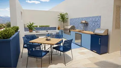 a kitchen with blue cabinets and a wooden table and chairs at Chic Residences Steps from Beverly Hills & Sony Pictures in Los Angeles