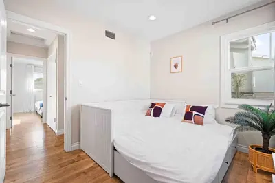 a white bedroom with a large white bed with pillows at Charming Modern Escape with Outdoor Living in San Dimas