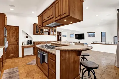 a large kitchen with wooden cabinets and a counter top at Silverstrand Beach House in Oxnard