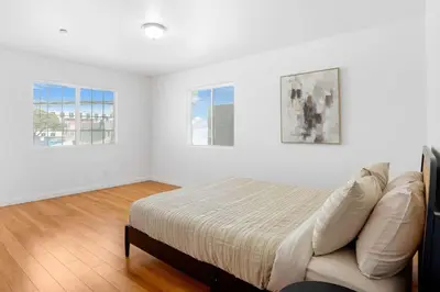 a white bedroom with a bed and two windows at Spacious Culver City 4BR - Half Block from Amazon in Los Angeles