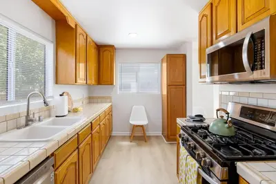 a kitchen with wooden cabinets and a stove top oven at Spacious Culver City 4BR - Half Block from Amazon in Los Angeles