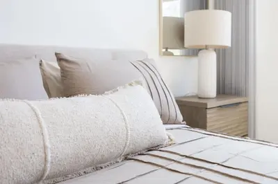 a white bed with a white pillow and a lamp at Modern Townhouse Near Disneyland & OC Beaches in Covina