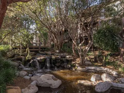 a waterfall in a garden with rocks and trees at Lux Marina Village with parking in Los Angeles