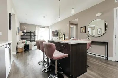 a kitchen with pink bar stools and a mirror at Elegant 2BD WeHo Apartment in Los Angeles