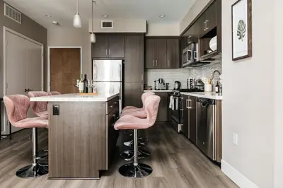 a kitchen with pink bar stools at a counter at Elegant 2BD WeHo Apartment in Los Angeles