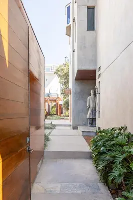 a walkway between two buildings with a statue in the distance at Garden Oasis by the Sea in Los Angeles