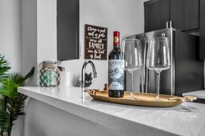 a bottle of wine sitting on a counter with two wine glasses at Heart of La, Walk to everything!! in Los Angeles